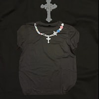 a black t - shirt with a cross on it